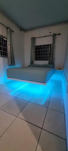 Pokój z łóżkiem z niebieskimi światłami na podłodze w obiekcie Multigen-Lip of the City Escape w mieście Castries