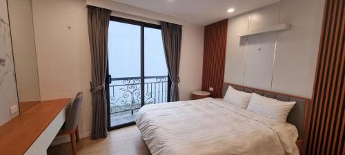 a bedroom with a bed and a large window at Era Cozy Apartment in Hanoi