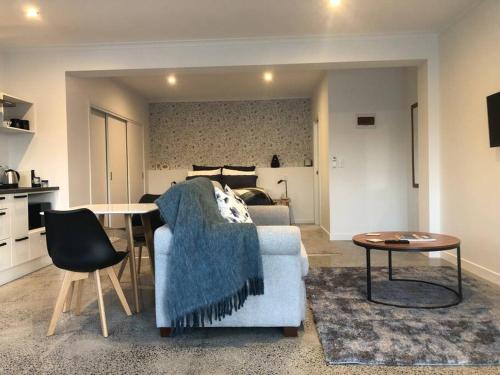 a living room with a couch and a table at Location, luxury and stylish comfort in Hamilton