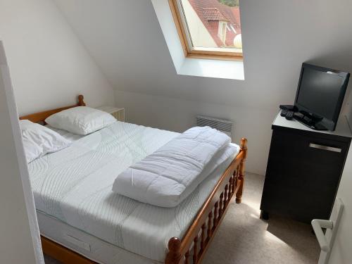 une petite chambre avec un lit et une télévision dans l'établissement Charmante Maisonnette avec Jardin, Proche Plage et Commerces à Fort-Mahon-Plage - FR-1-482-144, à Fort-Mahon-Plage