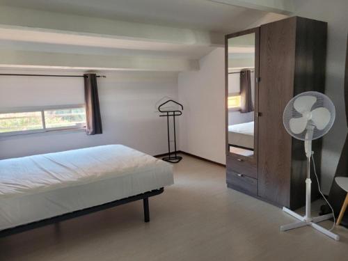 une chambre avec un lit, un ventilateur et un miroir dans l'établissement Appartement T2+Mezzanine 6 pers, Piscine, Parking, à 300m de la Plage - Argelès-sur-Mer - FR-1-388-224, à Argelès-sur-Mer