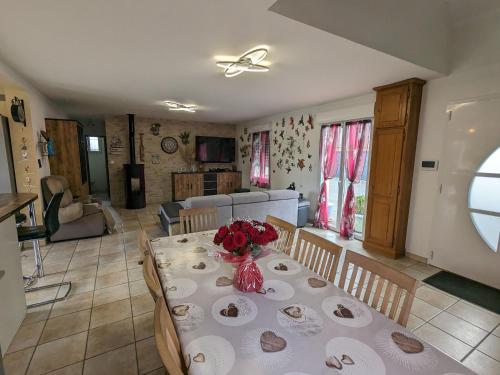 a table with a vase of flowers on it in a living room at Titre proposé : Gîte familial avec piscine chauffée, jardin et jeux pour enfants à l'orée de la forêt d'Orléans - FR-1-590-432 in Mareau-aux-Bois