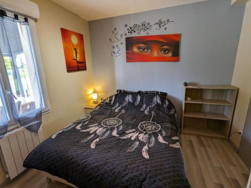 a bedroom with a bed and a painting on the wall at Titre proposé : Gîte familial avec piscine chauffée, jardin et jeux pour enfants à l'orée de la forêt d'Orléans - FR-1-590-432 in Mareau-aux-Bois