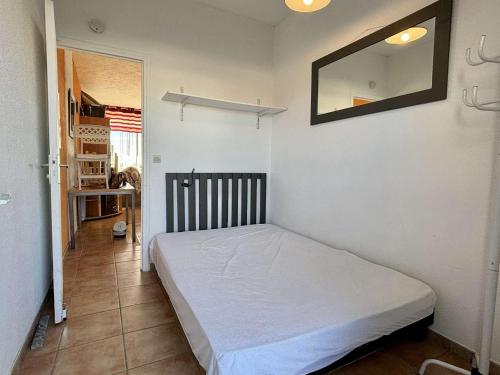 - une chambre avec un lit dans une pièce avec un miroir dans l'établissement Appartement rénové 2 pièces 4 pers avec jardin privatif - Plage à 2 pas - Port-la-Nouvelle - FR-1-229C-95, à Port-la-Nouvelle