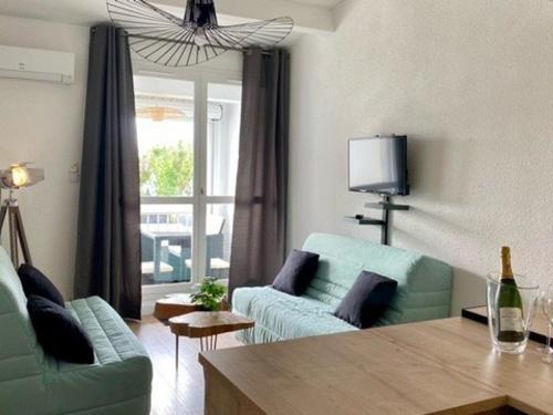 un salon avec un canapé et une table dans l'établissement Studio Rénové et Climatisé avec Terrasse, Parking Privé et Options Confort à Marseillan - FR-1-387-209, à Marseillan