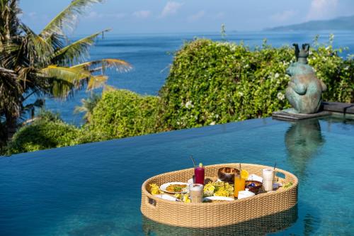 Una canasta de comida en el agua junto a una piscina en Shunyata Villas Bali, en Seraya