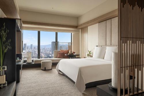 a bedroom with a large white bed and a large window at Four Seasons Hotel Osaka in Osaka