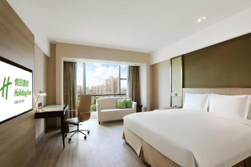 um quarto de hotel com uma cama e uma televisão em Holiday Inn Shanghai Pudong Nanpu, an IHG Hotel em Xangai