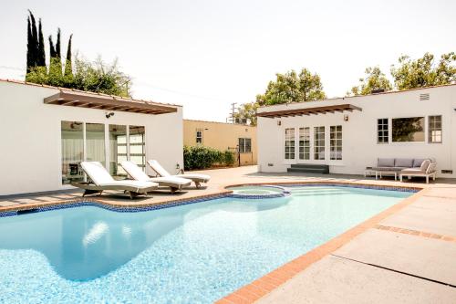 a swimming pool with chairs and a house at Monthier Melrose PO7H2O0 in Los Angeles