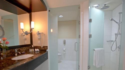 a bathroom with a shower and a sink and a mirror at InterContinental Abu Dhabi by IHG in Abu Dhabi