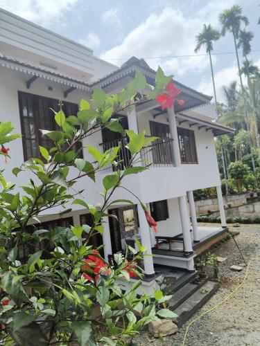 a white house with a red star on it at Ananda Holiday Home in Ambalavayal