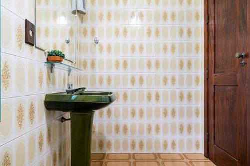 a bathroom with a green sink on a wall at Suítes Casa Verde in Arraial do Cabo