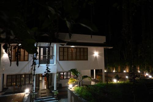 a house with lights in front of it at night at Ananda Holiday Home in Ambalavayal