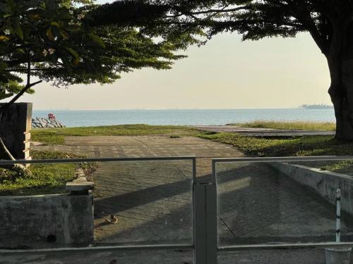 a view of a beach with a tree and the ocean at My Beach Villa in Port Dickson