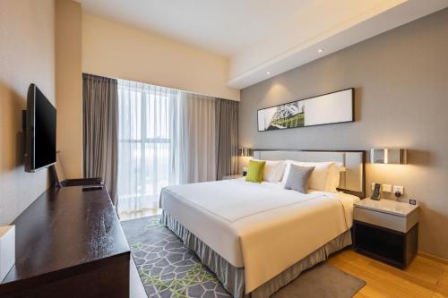 天津的住宿－天津奥体壹棠服务公寓(天津招商美伦辉盛坊国际公寓)，酒店客房设有一张大床和一台电视。