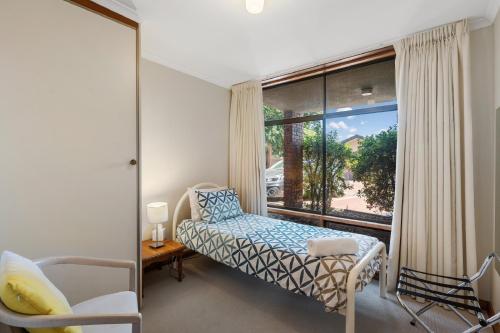 - une chambre avec un lit et une grande fenêtre dans l'établissement By The Sea Beachfront Apartment Wifi, à Encounter Bay
