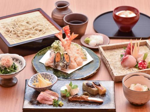 a table topped with plates of sushi and other food at Hot Cross Point Santa Monica in Miyako Island