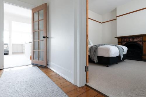 une chambre avec un lit et une porte dans l'établissement Timeless Elegance with City Views Wi-Fi & Parking, à Launceston