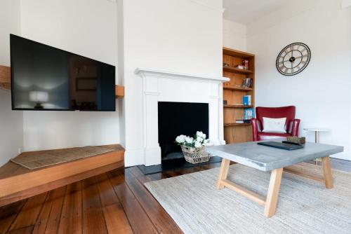 a living room with a table and a fireplace at Timeless Elegance with City Views Wi-Fi & Parking in Launceston