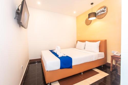 a bedroom with a bed with a tv on the wall at Grand Elevation Hotel in Phnom Penh