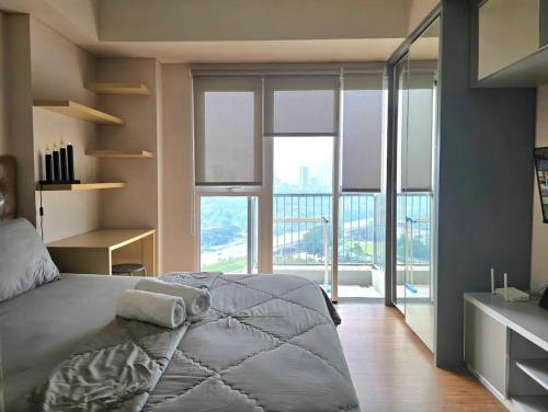 um quarto com uma cama grande e uma janela grande em Apt Casa De Parco Studio Tema Gray With Wifi, Pool and Netflix em Samporo