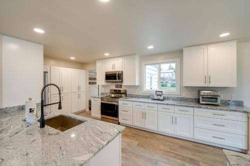 a kitchen with white cabinets and marble counter tops at Oak Harbor Vacation Rental in Oak Harbor