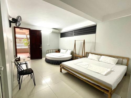 een slaapkamer met 2 bedden en een tafel en een stoel bij Hotel Me Kong 2 in Ha Long
