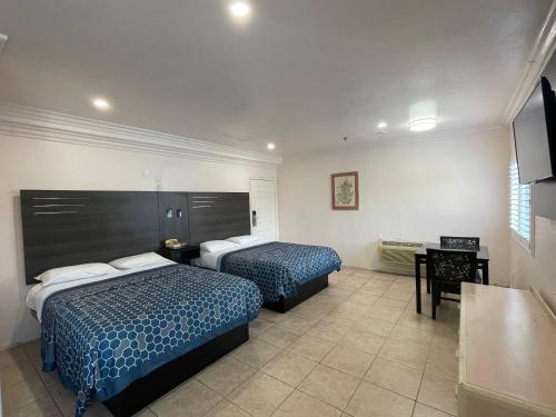 ein Hotelzimmer mit 2 Betten und einem TV in der Unterkunft Diamond Inn in North Hills