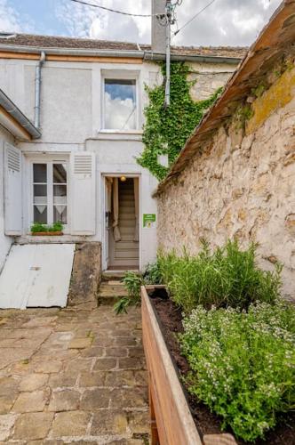 une maison blanche avec un mur en pierre et une porte dans l'établissement Countryside Cottage samois-sur-seine, à Samois-sur-Seine