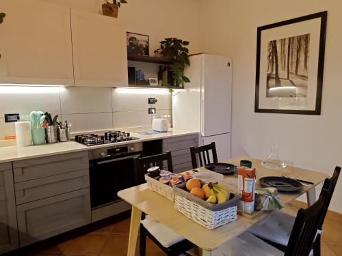 a kitchen with a table with a basket of fruit on it at B&B Monte Adone in Santa Cecilia