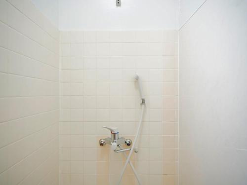 um chuveiro com uma mangueira numa casa de banho em azulejos brancos em Mcity in WAKASA - Vacation STAY 84253v em Naha