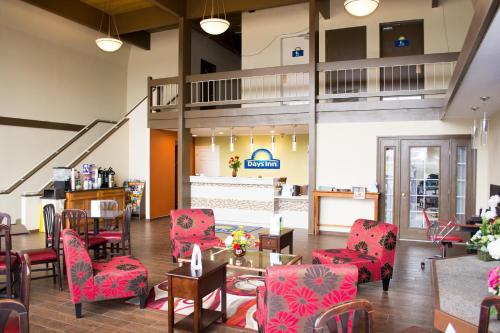 a lobby with red chairs and tables and a staircase at Days Inn by Wyndham Klamath Falls in Klamath Falls