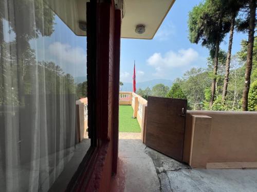 an open door of a house with a view of a yard at Mount Everest Hotel & Resort Nagarkot in Nagarkot