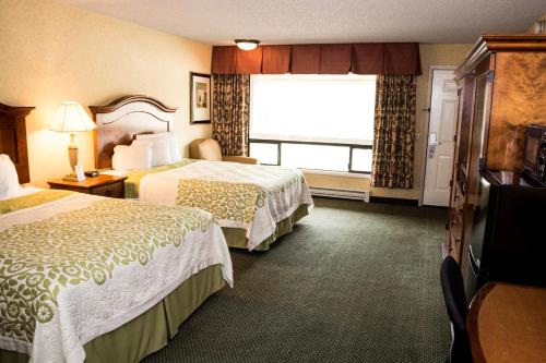 a hotel room with two beds and a window at Days Inn by Wyndham Klamath Falls in Klamath Falls