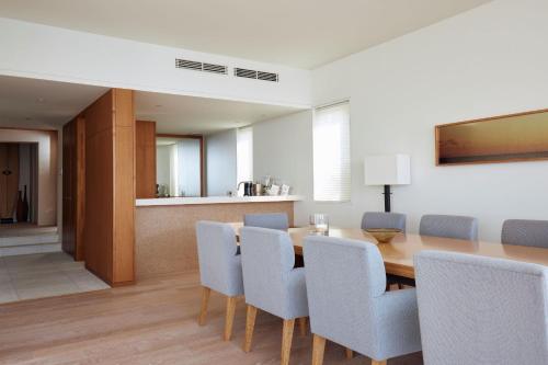 a dining room with a wooden table and chairs at 葉山 Syla Hotel Zushi-Hayama - オーシャンビューの一棟貸切 - 最大6名滞在可 in Yokosuka