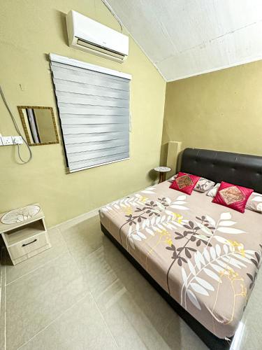 ein Schlafzimmer mit einem Bett und ein Fenster mit einem Blindfenster in der Unterkunft Dusun Indah Cottage 3 in Bayan Lepas