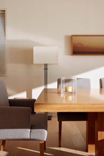 a dining room with a wooden table and chairs at 葉山 Syla Hotel Zushi-Hayama - オーシャンビューの一棟貸切 - 最大6名滞在可 in Yokosuka