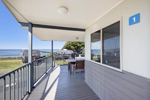 a balcony of a house with a table and chairs at Reflections Bonny Hills - Holiday Park in Lake Cathie