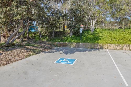 a parking lot with a handicapped sign in a park at Reflections Bonny Hills - Holiday Park in Lake Cathie