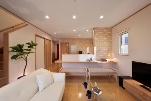a living room with a white couch and a tv at Crystal Besso Shirahama in Shirahama