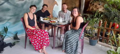 a group of people sitting around a table at White Arcadia cottage in Ella