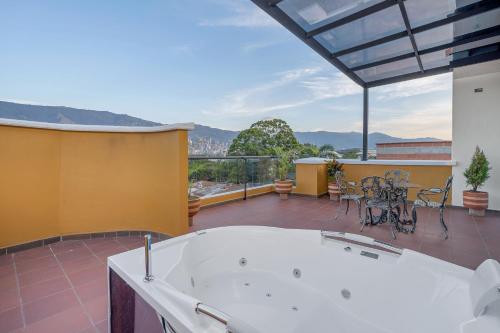 a large room with a tub and a balcony with mountains at MEDELLIN- Cerca al Poblado-401 in Medellín