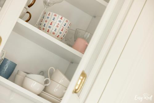 a drawer filled with cups and other items at Nowoczesny Domek z Jacuzzi 1 in Wrzosowo