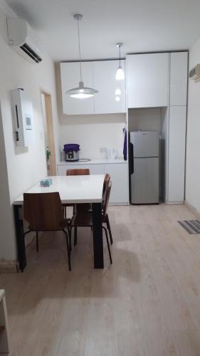 a room with a table and chairs and a kitchen at Santai Homestay in Kota Kinabalu