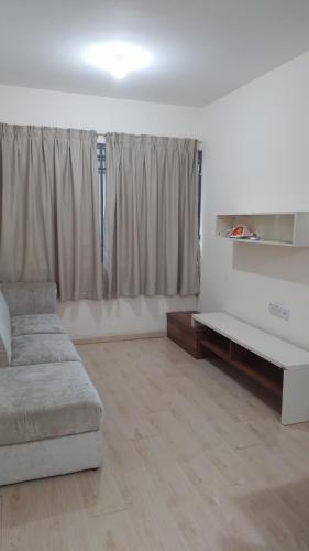 ein Wohnzimmer mit einem Sofa und einem Tisch in der Unterkunft Santai Homestay in Kota Kinabalu
