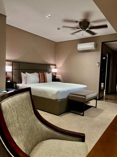 a bedroom with a large bed and a couch at The Plaza Garden Hotel and Residences in Baguio