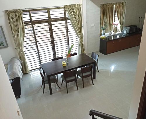 a dining room table and chairs in a room at Eden Nomad Living in Batu Ferringhi