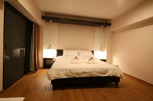 a bedroom with a bed with two flowers on it at Baanthanam Nont in Nonthaburi