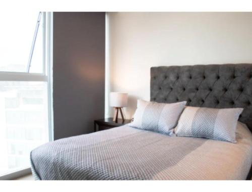 a bedroom with a large bed with a large window at ANDARES, MAGNIFICO DEPTO DE LUJO Piso 19 LOBBY 33 in Guadalajara