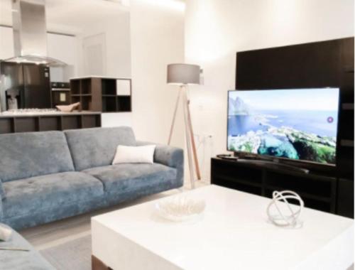 a living room with a blue couch and a flat screen tv at ANDARES, MAGNIFICO DEPTO DE LUJO Piso 19 LOBBY 33 in Guadalajara